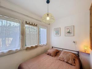 une chambre avec un lit et une grande fenêtre dans l'établissement Appartement F1 avec Terrasse et Clim, à 650m des Thermes - Lamalou-les-Bains - FR-1-451-191, à Lamalou-les-Bains