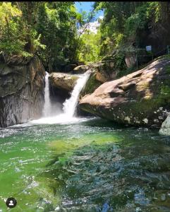a waterfall in the middle of a river at Apê do NADINHO in Caparaó Velho