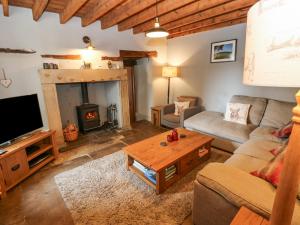 a living room with a couch and a fireplace at Castle Hill Cottage in Middleham