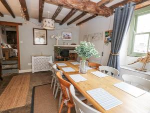 a dining room with a wooden table and chairs at Castle Hill Cottage in Middleham