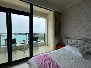 a bedroom with a bed and a view of the ocean at Matsu Star Yang Homestay in Beigan