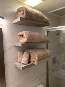 a bathroom with shelves with towels and a shower at Seas the Day TCI -Sonos, Covered Balcony, hot tub in Wheeland Settlement