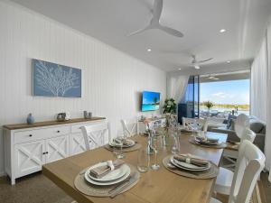 comedor con mesa con sillas y cocina en Casa del Sol, en Nelly Bay