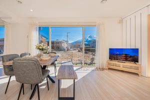a living room with a table and a television at New Open! Collab House 富士山眺望 送迎無料 BBQ 器具無料貸出 in Fujikawaguchiko