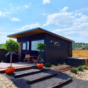 a small black house with a patio and a table at ABODE at East Zion in The Fields in Orderville
