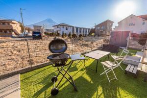 a grill sitting on the grass on a balcony at New Open! Collab House 富士山眺望 送迎無料 BBQ 器具無料貸出 in Fujikawaguchiko