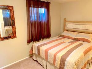 a bedroom with a bed and a mirror and a window at Enjoy a Sweet Retreat in downtown Kanab in Kanab