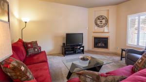 ein Wohnzimmer mit roten Möbeln und einer Uhr an der Wand in der Unterkunft Kanab Townhome Pool and Hot Tub Pets OK in Kanab + 45 Fotos