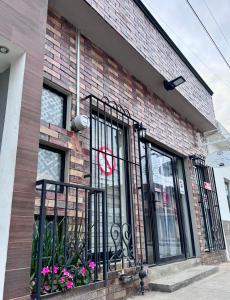 a brick building with a black fence and flowers at Casa Josefina Allende Nuevo Leon in Allende