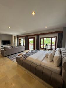 a large bedroom with a large bed and a couch at Uluwatu Stay's Deluxe Suite #5 in Uluwatu +21 photos