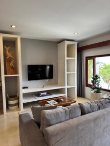 a living room with a couch and a flat screen tv at Uluwatu Stay's Deluxe Suite #5 in Uluwatu