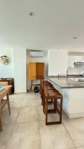 eine Küche mit einer Theke und einem Tisch darin in der Unterkunft Bello departamento con vistas al mar in Acapulco