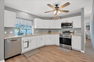 a kitchen with white cabinets and a ceiling fan at DBD1014 in Port Charlotte