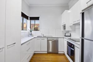 a white kitchen with a sink and a dishwasher at Bendigo Signature Accommodation on Chapel in Bendigo
