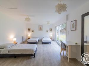 two beds in a room with a desk and two beds at Séjourner au cœur de la nature entre Tours et Angers - FR-1-622-101 in Saint-Philbert-du-Peuple