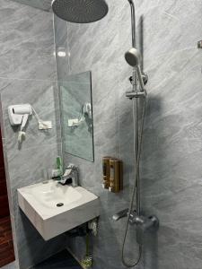 a bathroom with a sink and a shower at NH Hotel in Hanoi