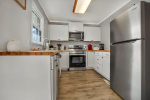 a kitchen with white cabinets and a stainless steel refrigerator at A Shore Thing in North Myrtle Beach! 4 Bedroom Home! in Myrtle Beach