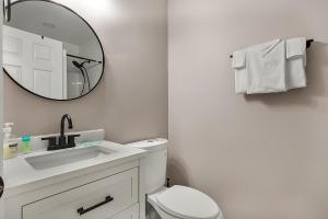 a white bathroom with a sink and a mirror at A Shore Thing in North Myrtle Beach! 4 Bedroom Home! in Myrtle Beach +21 photos