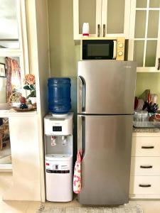 a kitchen with a stainless steel refrigerator and a microwave at VIP 4-Bedroom House in Butuan