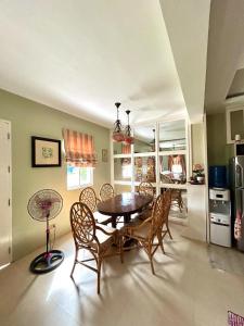 a dining room with a table and chairs and a kitchen at VIP 4-Bedroom House in Butuan