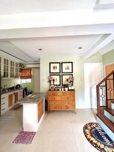 a kitchen with green walls and a wooden island at VIP 4-Bedroom House in Butuan +15 photos