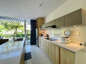 a kitchen with wooden cabinets and a counter top at Oceanami Villas Resort Beach in Long Hai