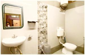 un bagno con lavandino, water e specchio di A PREMIUM VARANASI HOTEL D - S - R E S I D E N C Y - fully Air Conditioned hotel at Prime Location - Hygiene & Spacious Room - with wifi Facilities - BEST HOTEL IN VARANASI a Varanasi