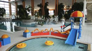 萨加尔德Precise Resort Rügen Apartments & SPLASH Erlebniswelt的游泳池的水滑梯