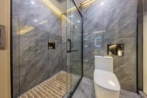a bathroom with a toilet and a glass shower at 天门山云尚景豪酒店 in Zhangjiajie