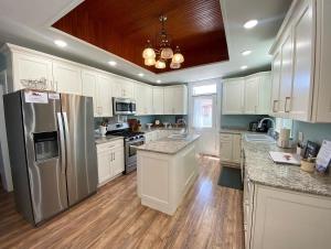 una cucina con armadi bianchi e frigorifero in acciaio inossidabile di Stunning Historic Home Lots of Space In Town a Kanab