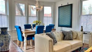 a living room with a couch and a table with blue chairs at Stunning Historic Home Lots of Space In Town in Kanab