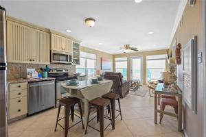 a kitchen and living room with a table and chairs at Seascape 1111 condo in Galveston