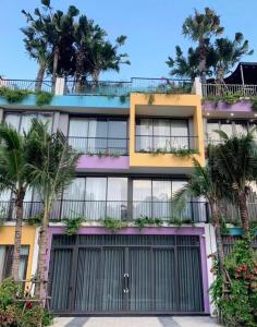 a building with palm trees in front of it at Villa Ốc Biển Xanh - Flamingo Hải Tiến in Thanh Hóa
