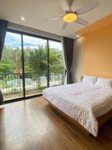 a bedroom with a bed and a large window at Villa Ốc Biển Xanh - Flamingo Hải Tiến in Thanh Hóa