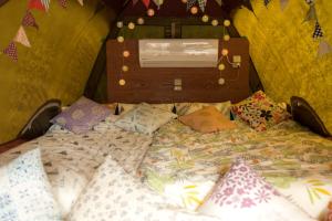 a bed in a room with pillows on it at Muribushi-PLUS Gramping TENT in Motobu