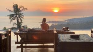 スンギギにあるVilla Umbrella Lombokの夕日を眺めながらソファに座っている女性