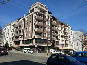 a tall building with cars parked in front of it at Apartment Nova in Burgas