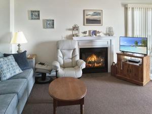 een woonkamer met een bank en een open haard bij Sea Breeze W007 Wonderful Beachfront Oceanfront property for the whole family 1897 in Wells