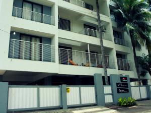 a white building with a fence in front of it at Aashiyana Inn in Nashik