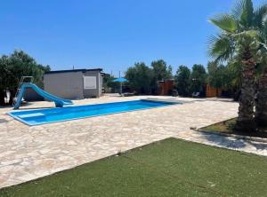 a swimming pool with a slide and a playground at Gabrijela House in Pirovac