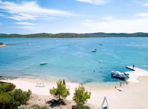 a beach with a boat and people in the water at Gabrijela House in Pirovac