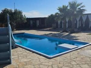a large blue swimming pool in a yard at Gabrijela House in Pirovac +11 photos