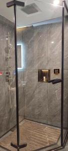 a bathroom with a shower with a clock on the wall at 天门山云尚景豪酒店 in Zhangjiajie