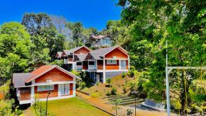 a house on top of a hill with trees at Monarda Resort in Padinjarathara
