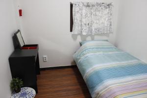 - une petite chambre avec un lit et une fenêtre dans l'établissement Jiwoljang Guesthouse, à Séoul