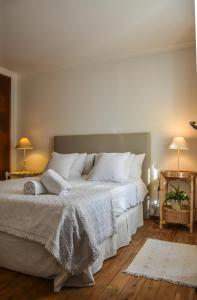 a bedroom with two beds with white pillows at Casa das Escadinhas in Ericeira