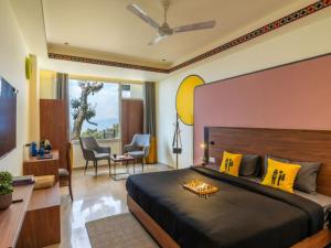 ein Schlafzimmer mit einem großen schwarzen Bett mit gelben Kissen in der Unterkunft The Hosteller Dalhousie in Dalhousie