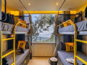 a room with bunk beds and a window at The Hosteller Dalhousie in Dalhousie