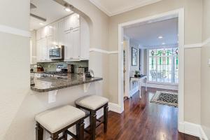 a kitchen with white cabinets and a counter with stools at Success Historic - Luxury Home for Large Groups - 5 Min Walk to FSU in Lakeland
