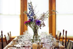 a table with a vase with flowers in it at Palazzo Hudson - Luxury Pool, Hot Tub, and Sauna in Hudson +85 photos